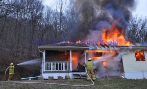 Firefighters battle a fire at the home of Donald Cassidy on Ky. Rt. 344. - Photo by Dennis Brown