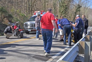 Rescue personnel prepare to transfer a motorcycle operator into an ambulance following an accident near Vanceburg Wednesday afternoon as Deputy Eric Poynter examines the motorcycle. - Photo by Dennis Brown