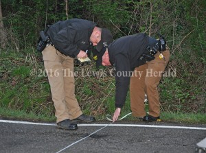 Deputy Matt Ross and Deputy Mark Sparks take measurements at the scene of an accident Thursday evening at Dugan's Curve, east of Vanceburg on Ky. Rt. 8. - Photo by Dennis Brown