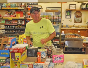 Steve Applegate waits on a customer at Steve's Market. The neighborhood grocery will close on Saturday. - Photo by Dennis Brown