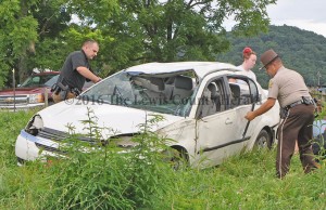 Deputy Matt Ross, left, and Sheriff Johnny Bivens examine the scene of a single vehicle accident Wednesday afternoon on Ribolt-Epworth Road. A Tollesboro woman was airlifted to a Huntington, West Virginia, trauma center following the crash. - Photo by Dennis Brown