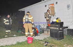 Firefighters work to remove smoke from a Quicks Run residence after a small fire. - Photo by Dennis Brown