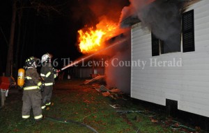 Firefighters work to contain a fire at the home of Rocky Jamison on Montgomery Road. - Dennis Brown Photo