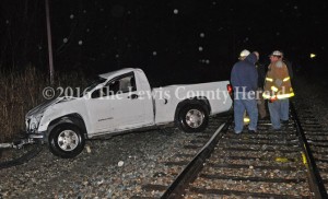 Emergency responders examine the scene of a fatal accident Sunday night at Quincy. The driver of the pick-up was ejected from the vehicle and perished at the scene. - Dennis Brown Photo