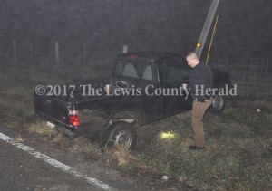 Deputy Eric Poynter looks over the scene of a single vehicle accident early Sunday in which the vehicle's operator left before first responders arrived. - Dennis Brown Photo