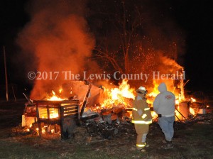 Firefighters Hammer Cooper and Curtis Brewer at the scene of a mobile home fire in Garrison early Friday. The cause of the fire is under investigation. - Dennis Brown Photo