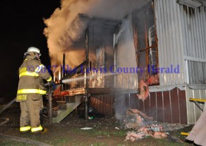 A Garrison firefighter works to bring a mobile home fire under control Saturday night. No injuries were reported as a result of the incident. The cause is under investigation. - Dennis Brown Photo