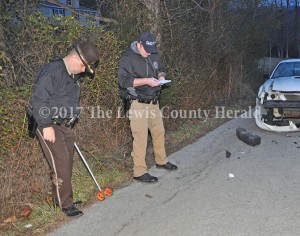 Sheriff Johnny Bivens and Deputy Matt Ross collect information at the scene of a fatal accident on Rock Creek Road at Quincy Monday evening. - Dennis Brown Photo