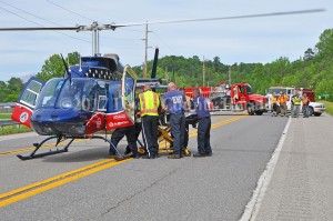 Emergency workers load a patient onto a medical helicopter following an accident Monday afternoon at Garrison. - Dennis Brown Photo