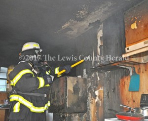 Black Oak Fire Chief Curtis Brewer checks inside a kitchen wall for signs of fire at a home on Rock Run. The home sustained extensive smoke and water damage as a result of the fire. - Dennis Brown Photo