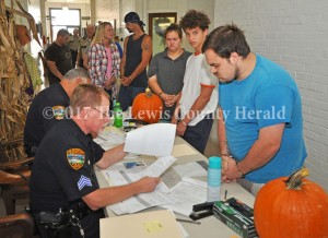Suspects wait in line to be processed Friday during Operation Fall Harvest. The drug roundup began before daylight. - Dennis Brown Photo