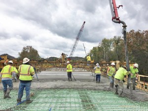 Workers work to place a concrete deck on the new Garrison bridge. - Brandon Howe Photo